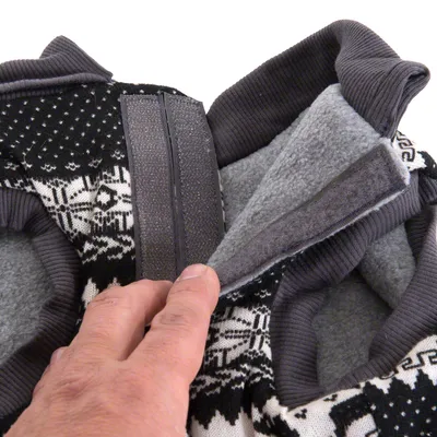 Close-up of a hand opening the hook-and-loop fastener on a fleece-lined garment, showing how to adjust or secure the closure.