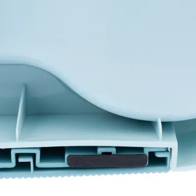 Close-up of a light blue plastic product showing an internal compartment with divider and a black strip, possibly indicating a sealing or locking mechanism.