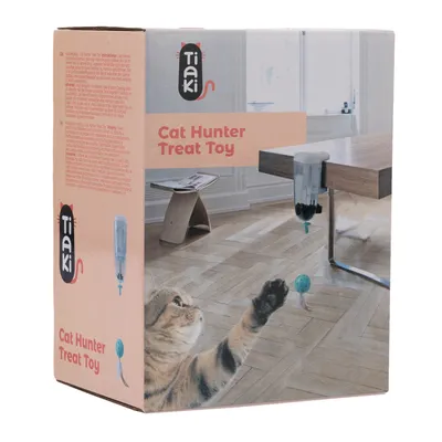 Tiaki Cat Hunter Treat Toy. La confezione mostra un gioco che distribuisce snack, con un gatto che lo afferra. Adatto per montaggio su tavolo.