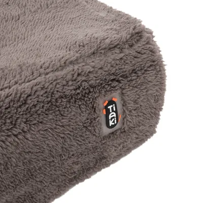 Tiaki-Logo auf grauem, flauschigem Stoff. Detailaufnahme des Materials.