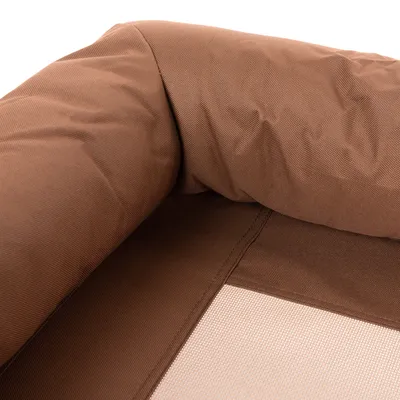 Close-up van bruin textiel met gewatteerde rand en netstof, mogelijk onderdeel van een huisdierenbed of tas.