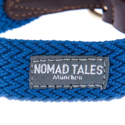 Nomad Tales München. Λεπτομερής προβολή μπλε πλεκτού υλικού με γκρι ετικέτα και δερμάτινες λεπτομέρειες.