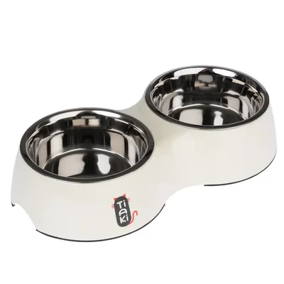 Double bowl made of stainless steel with white plastic holder, Tiaki logo with red cat tail visible.