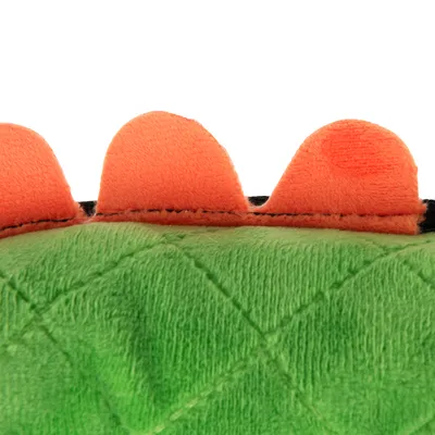 Plysmaterial i grøn med orange takker, detaljevisning af et legetøj eller tilbehør.