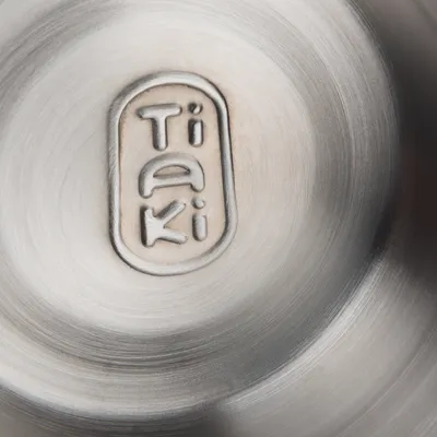 Inscription Tiaki gravée sur une surface métallique brossée