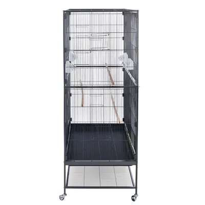 Grote vogelkooi van metaal met traliewanden, houten zitstokken en wielen aan de poten. Onderste deel met uitschuifbare lade en extra traliebodem.