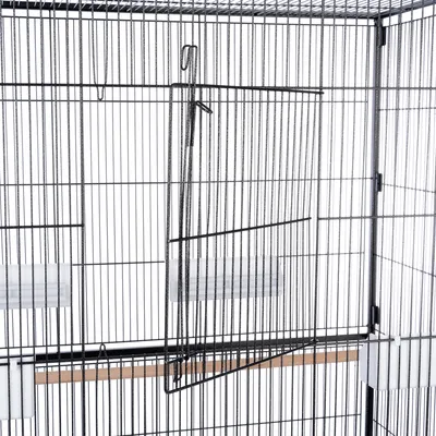 Vogelkooi van metaal met traliedeur, twee witte voederbakjes en een houten zitstok binnenin.