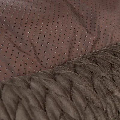 Gros plan sur deux matières : tissu marron à picots antidérapants et surface en peluche marron, visibles sur un accessoire pour animaux.