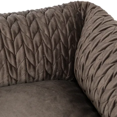 Gros plan sur le tissu en velours matelassé marron d’un panier ou coussin pour animal, avec motif en losanges visibles sur les rebords.