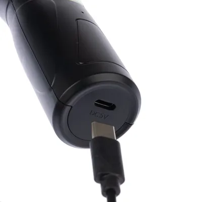 Nahaufnahme eines schwarzen Geräts mit USB-C-Anschluss und DC5V-Markierung, verbunden mit einem USB-C-Kabel.