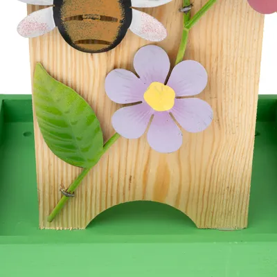 Trädekor med målad bi, lila blomma och grönt blad på grön bakgrund.