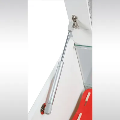 Molla a gas in metallo per apertura sicura e stabilizzazione di sportelli o porte, montata su mobile bianco.