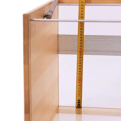 Custodia in legno con metro che indica un'altezza di circa 30 cm. Griglia metallica visibile sul retro.