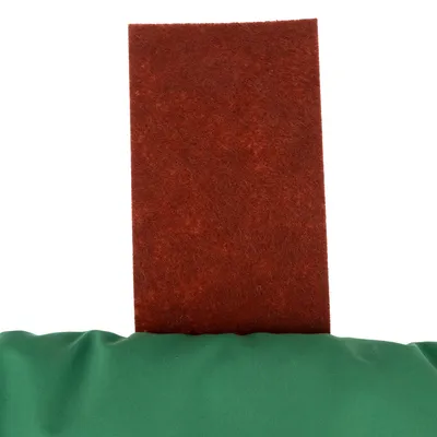 Red felt material on green fabric, possibly part of a product design or accessory.