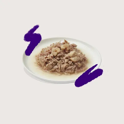 Gros plan de viande hachée et de crevettes en sauce sur une assiette blanche, présenté comme contenu du produit.