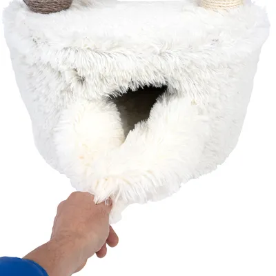 Hand zeigt die Öffnung eines weissen, flauschigen Katzenhöhlenbezugs mit weichem Material.