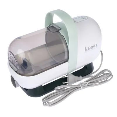 kooa. Electric pet grooming device with transparent container, green handle and power cord.