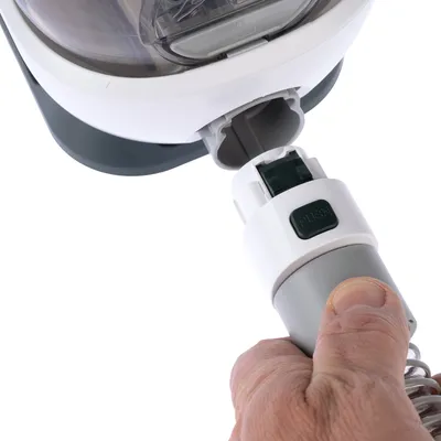 Hand showing how a grey accessory with 'Push' button is inserted into a white device.