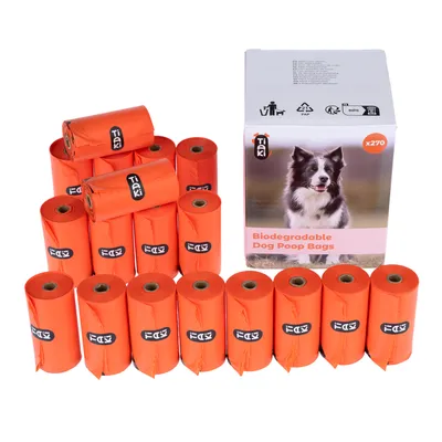 Rouleaux de sacs à déjections canines orange Tiaki, boîte avec photo de chien et texte visible : Biodegradable Dog Poop Bags, x270. Marque Tiaki sur chaque rouleau.