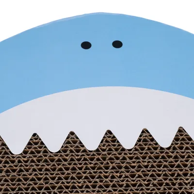 Surface en carton ondulé avec motif de requin bleu et blanc, deux points noirs pour les yeux visibles en haut.