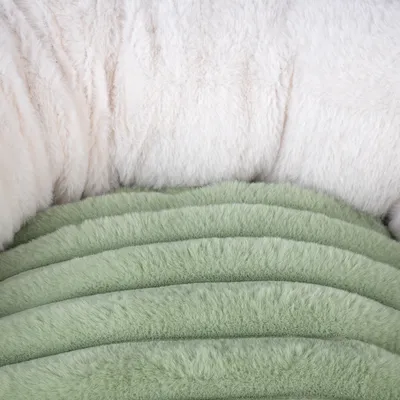 Nahaufnahme eines flauschigen, gesteppten Materials in Weiss und Grün, möglicherweise für Haustierbetten oder Decken geeignet.