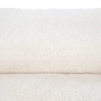 Close-up of white, fluffy fabric with soft texture, suitable for pet products such as beds or blankets.