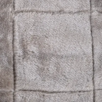 Nahaufnahme eines grauen, weichen Stoffmaterials mit Fellstruktur. Geeignet für Produktbeschreibung oder Materialdarstellung.