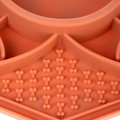Detailní záběr na oranžovou misku se vzorem kostí a přepážkami, vhodnou pro pomalé krmení.