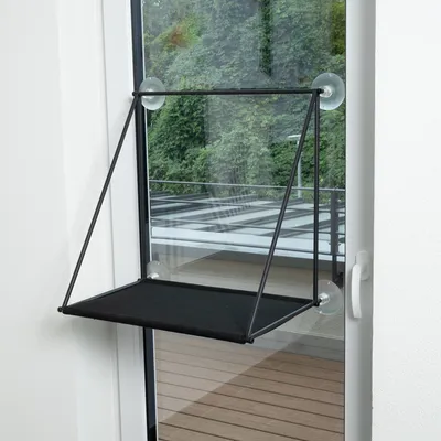 Plateforme noire en tissu fixée à une fenêtre par quatre ventouses, structure en métal visible, sans marque ni texte apparent.
