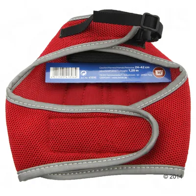 Red harness with label showing adjustable size 24-42 cm and lead length 1.20 m. Washable at 30 degrees Celsius. Barcode and manufacturer details visible.