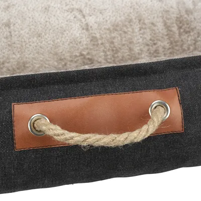 Detailaufnahme eines dunkelgrauen Stoffmaterials mit braunem Ledergriff und Seil, befestigt durch Metallösen.