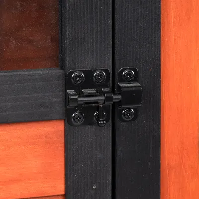 Detailný pohľad na čierny kovový zámok na drevených dverách s čiernym rámom.