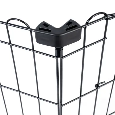 Détail d’un angle de parc pour animaux en métal noir avec connecteur en plastique noir, structure grillagée visible.