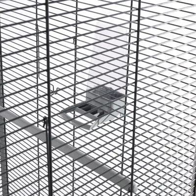 Close-up view of a birdcage with metal grid and integrated feeder made of transparent plastic.