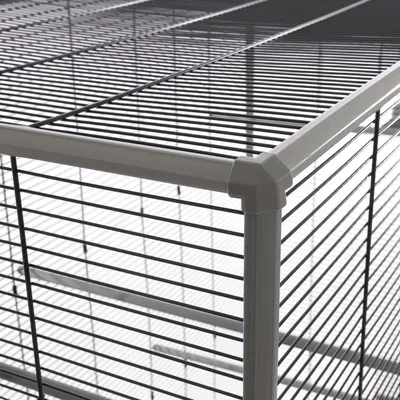Close-up view of an enclosure with metal mesh walls and sturdy plastic corner connectors.
