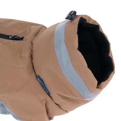 Vue rapprochée d'une capuche de manteau pour chien beige avec bande réfléchissante grise, doublure noire en tissu et cordon de serrage visible.