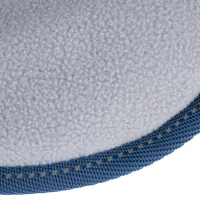 Gros plan sur une surface en tissu polaire gris avec bordure en tissu bleu et surpiqûres visibles.