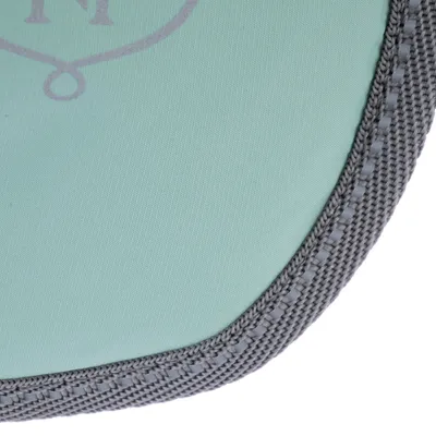 Détail d’un tissu vert clair avec bordure grise en nylon et lettre N partiellement visible. Matière textile et finition visibles.