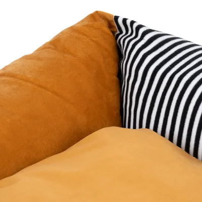 Nahaufnahme eines orangefarbenen Kissens und eines schwarz-weiss gestreiften Kissens. Material sichtbar: weicher Stoff.