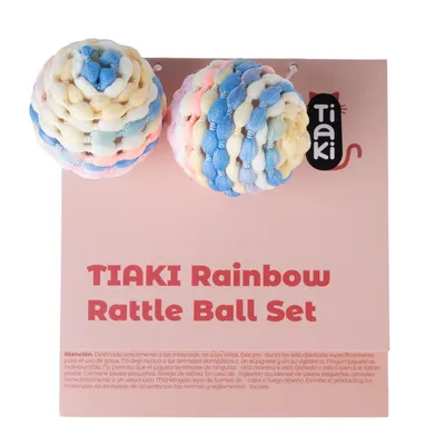 TIAKI Rainbow Rattle Ball Set, dos pelotas de juego de tela de colores sobre fondo rosa. Aviso: solo apto para mascotas, no para niños.