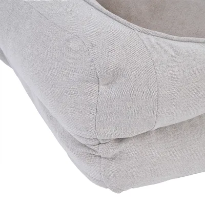 Close-up of light grey fabric material with padded seams, suitable for furniture or pet accessories.
