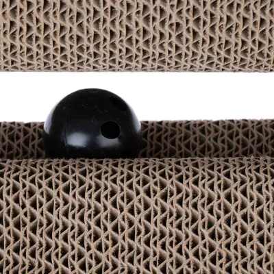 Μαύρη μπάλα με τρύπες ανάμεσα σε δύο στρώσεις κυματοειδούς χαρτονιού.