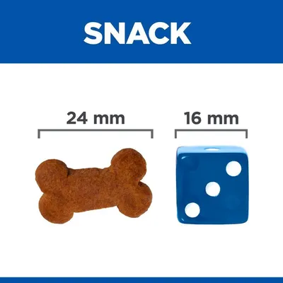 Сравнение на размер: лакомство с форма на кокал, 24 мм, до син зар с три точки, 16 мм. Надпис SNACK в горната част.