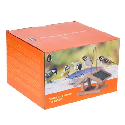 Envase de Tiaki Bird House 'Classic' con imagen de una casita de pájaros de madera y varios pájaros en un comedero. Nombre del producto y marca visibles.