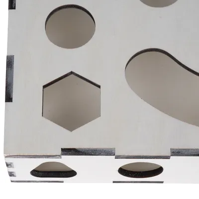 Boîte en bois clair avec découpes de formes géométriques : cercle, hexagone et forme allongée visible sur la surface. Matériau : bois.