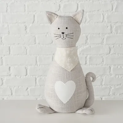 Dekorative Stoffkatze in Beige mit Herzmotiv und gemustertem Halstuch, geeignet als Wohnaccessoire.