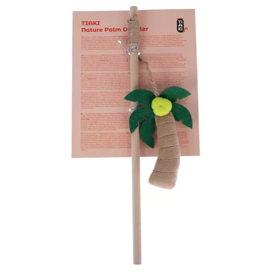 Baguette en bois avec jouet suspendu en forme de palmier, feuilles vertes et boule jaune, emballage avec texte visible « TIAKI nature Palm Dangler » et logo TIAKI.