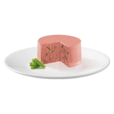 Rosa Pastete mit grünen Bohnenstücken, serviert auf einem weissen Teller. Ein Stück der Pastete ist herausgeschnitten, daneben liegen frische grüne Bohnen.
