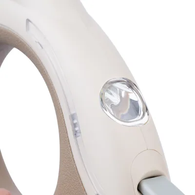 Primo piano di una maniglia ergonomica con pulsante o interruttore trasparente integrato.