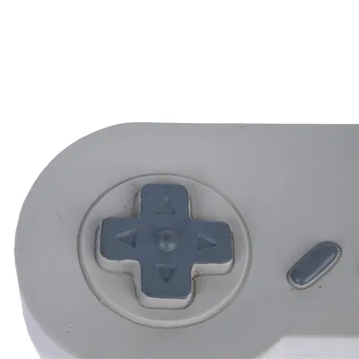 Prikaz izbliza sivog upravljačkog križa s tipkama za smjer i ovalnom tipkom, vjerojatno dio igračke ili uređaja.